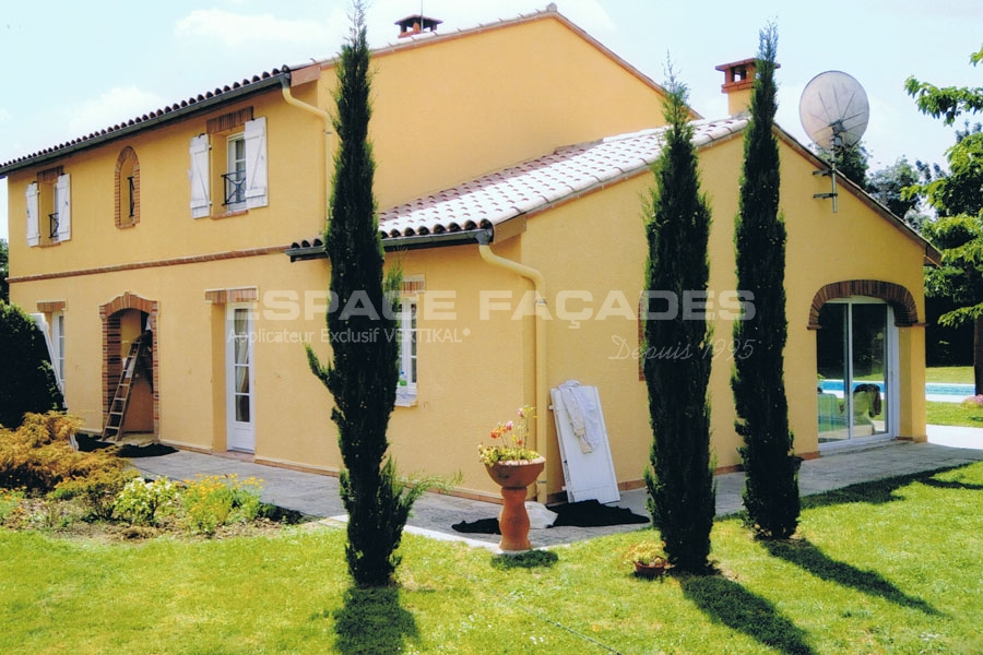 Maison rénovée par Espace Façades avec crépi jaune et jardin