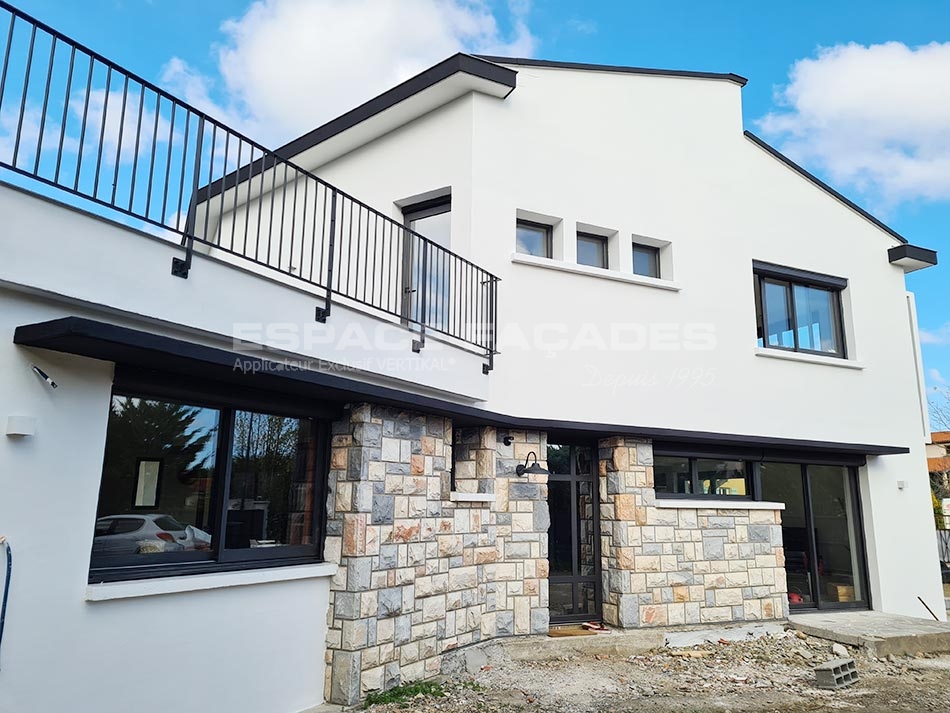 Maison moderne rénovée par Espace Façades avec balcon et pierres naturelles